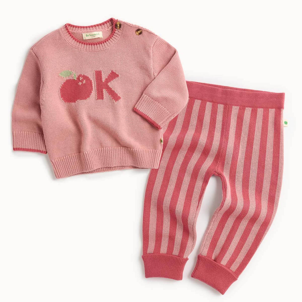 Pink cotton sweater with apple and 'OK' design and striped red pants 