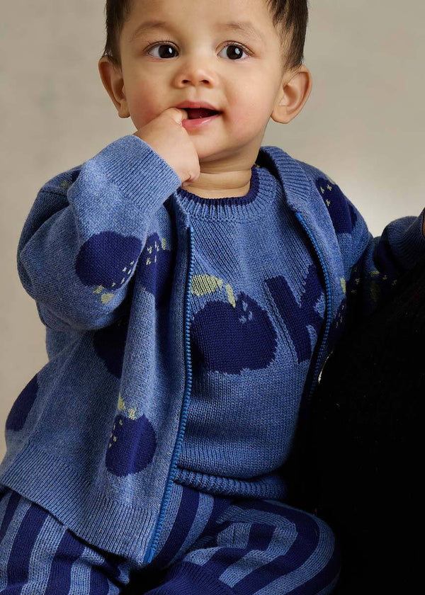 Child wearing a blue cotton cardigan with apple patterns 