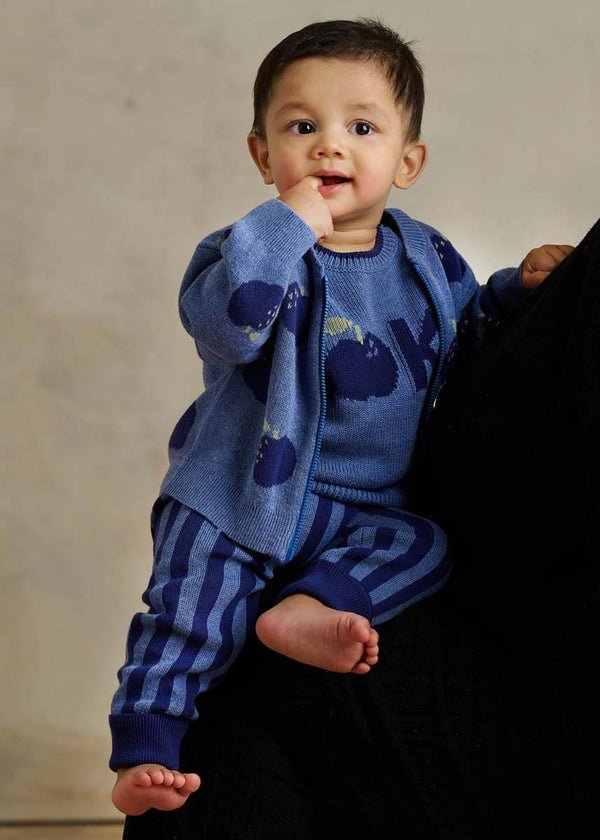 Baby wearing a blue cotton cardigan with apple pattern and blue striped cotton leggings