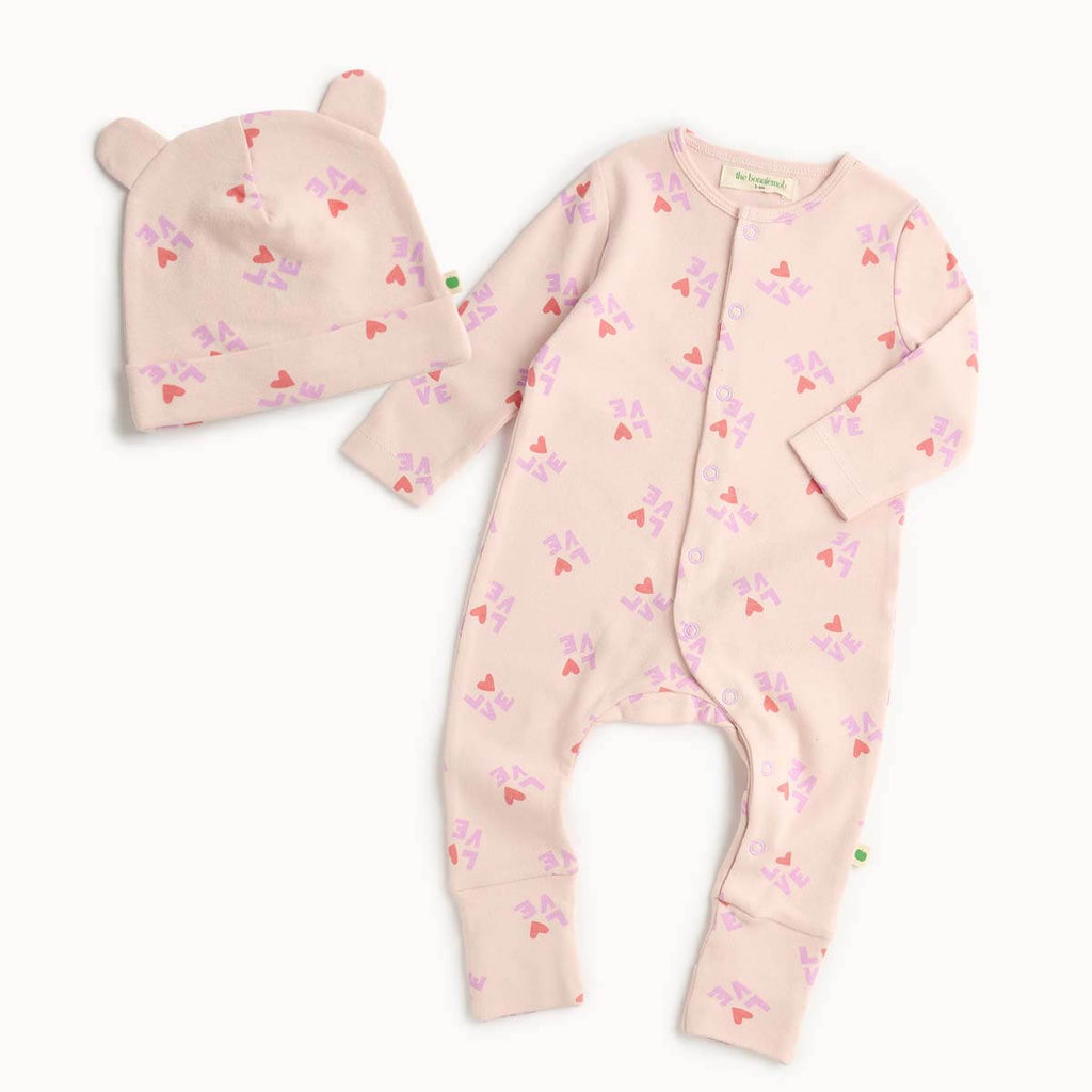 Cotton baby outfit set with pink sleepsuit and hat featuring heart patterns 