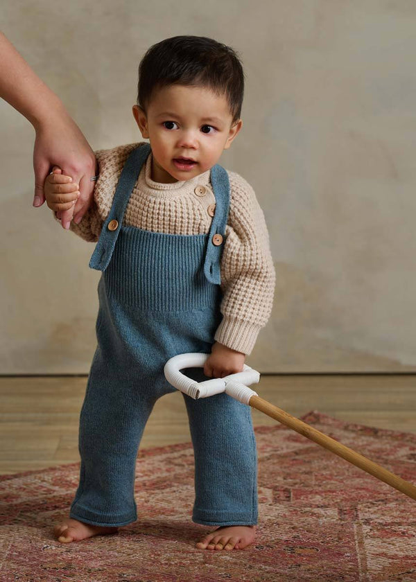 Child in blue knitted dungarees